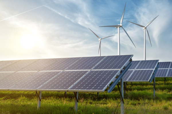 solar panels and wind generators under blue sky on sunset